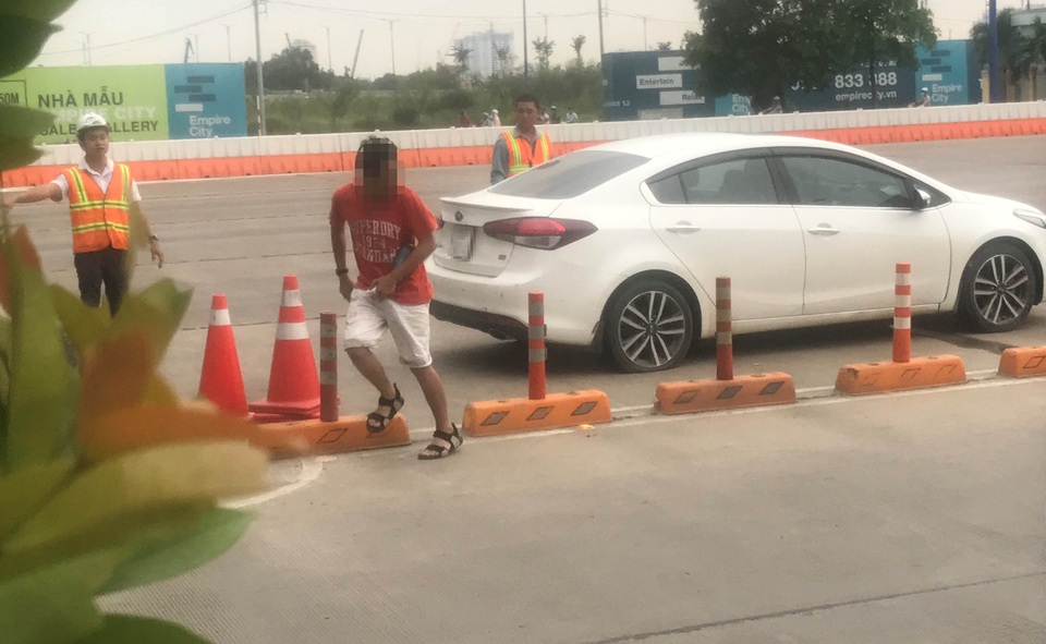 Người đàn ông (áo đỏ) lái xe ô tô có nhiều biểu hiển bất thường.