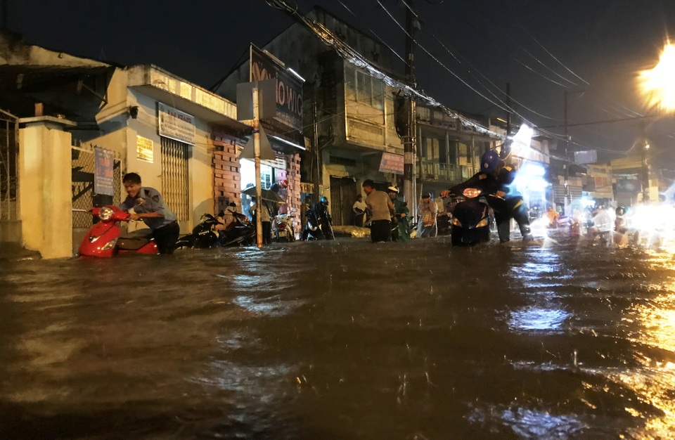 Đường sắt Nam Bắc tê liệt vì mưa cực lớn ở phía Đông Sài Gòn - 15 Người dân vất vả bì bõm lội nước để tìm đường về nhà trong đêm.