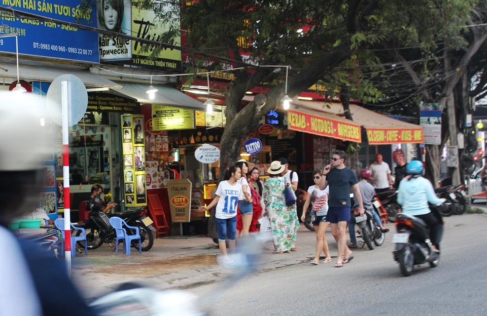Hàng loạt quán giải khát trên đường Nguyễn Thiện Thuật đưa bàn ghế ra chiếm vỉa hè khiến du khách phải đi lộn xộn trên lòng đường