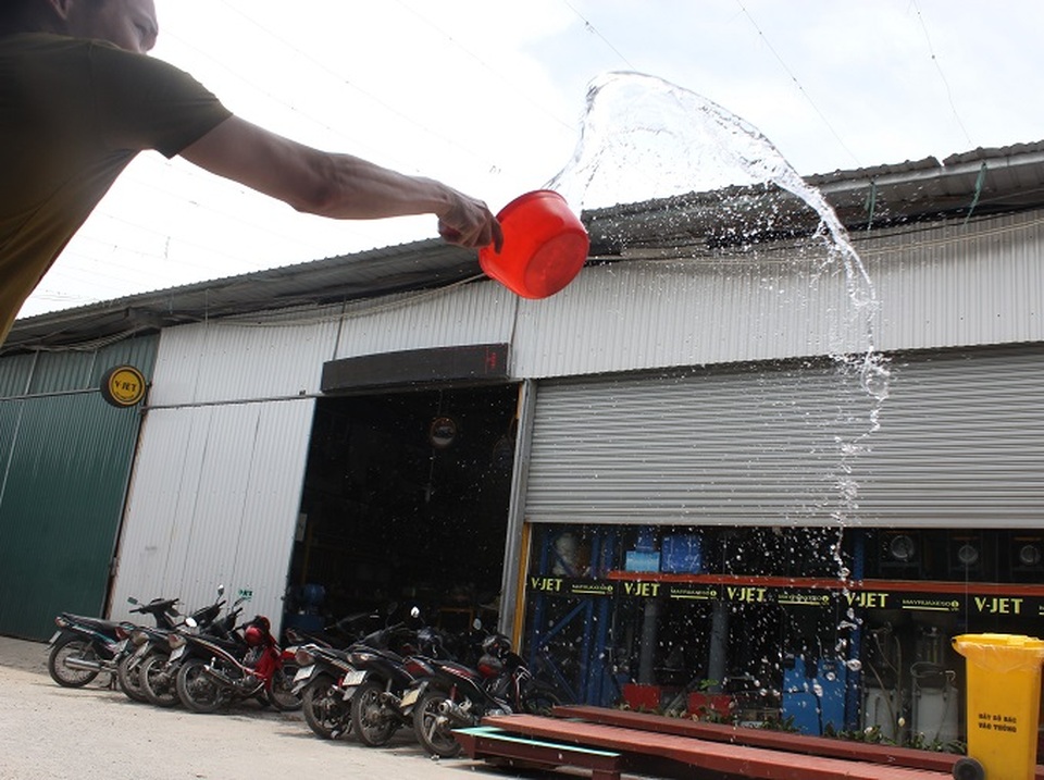 Người Hà Nội "săn" bóng râm trốn nắng nóng - 11
Trên phố Quan Nhân, người đàn ông liên tục đổ những xô nước ra trước cửa để tránh hơi nóng hắt lên từ dưới mặt đường.