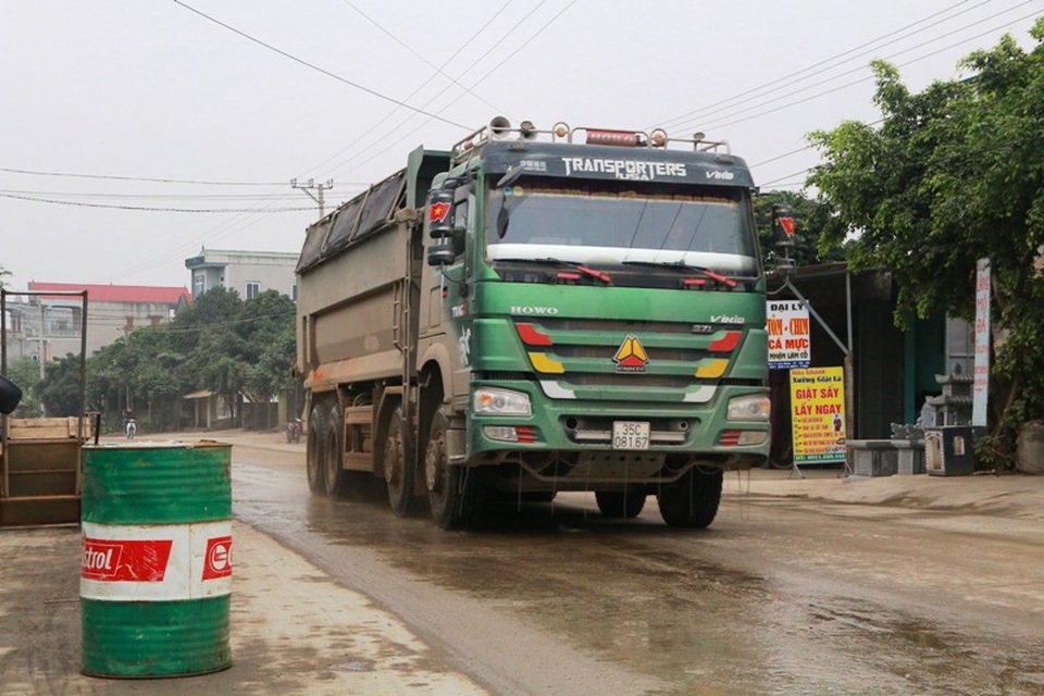 Người dân phải dùng thùng phuy ngăn không cho những chiếc xe siêu tải chạy sát vào nhà mình.