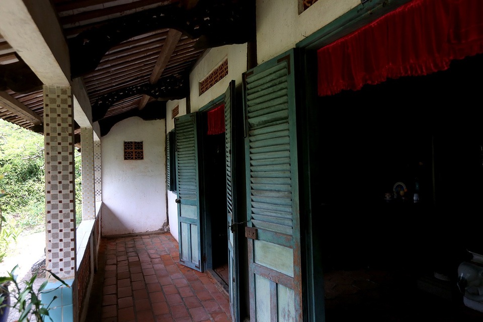 Hành lang, hiên và nền nhà được lát gạch Tàu, không gian rộng rãi hướng ra khu vườn rộng nên luôn mát mẻ. Cửa chính và các cửa sổ có song hình con tiện, bản gỗ.