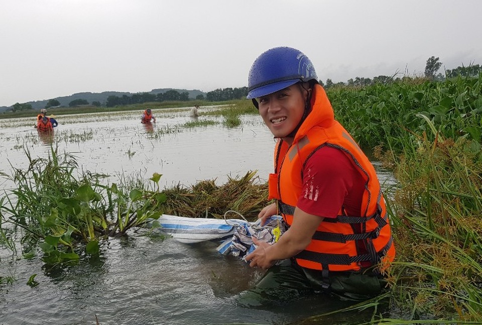 
Ngâm mình trong nước lũ gặt lúa giúp dân

