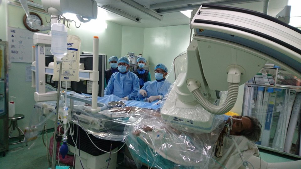 Cứu sống bệnh nhân ngưng tim, ngưng thở trước khi vào bệnh viện - 1 Các bác sĩ đang thực hiện can thiệp động mạch vành cho bệnh nhân Nh.
