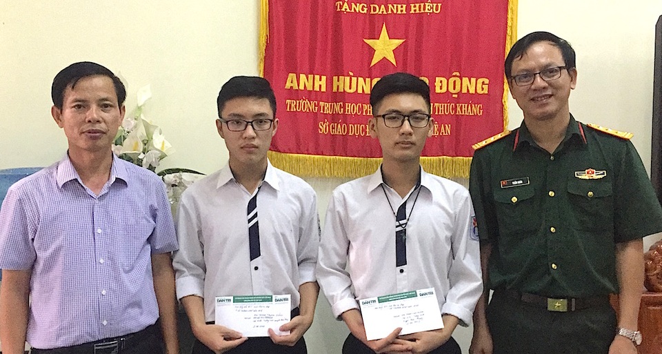 Thượng tá Trần Hoài - Trưởng đại diện báo Quân đội nhân dân trao 2 suất học bổng đến 2 em học sinh Trường THPT Huỳnh Thúc Kháng.