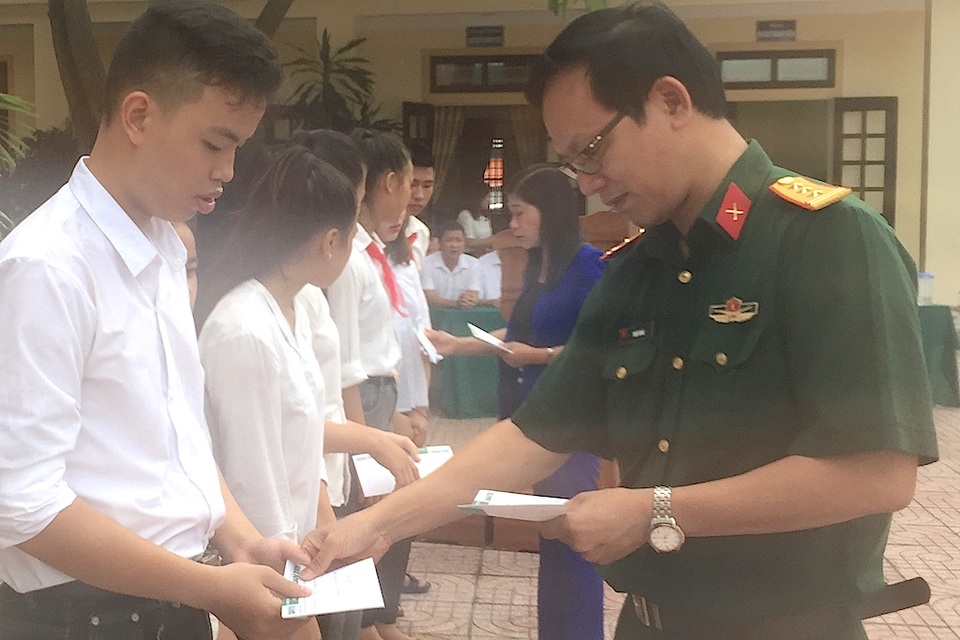 Thượng tá Trần Hoài - Trưởng đại diện Báo Quân đội nhân dân tại Nghệ An trao học bổng đến các em học sinh.