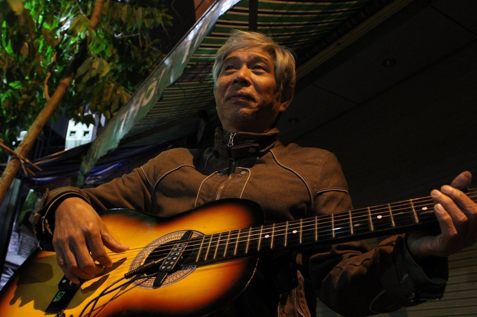 Tiếng đàn guitar mời khách lúc 0h của bác tài xe ôm trên phố cổ - 1
Người nghệ sĩ xe ôm già với cây đàn guitar.