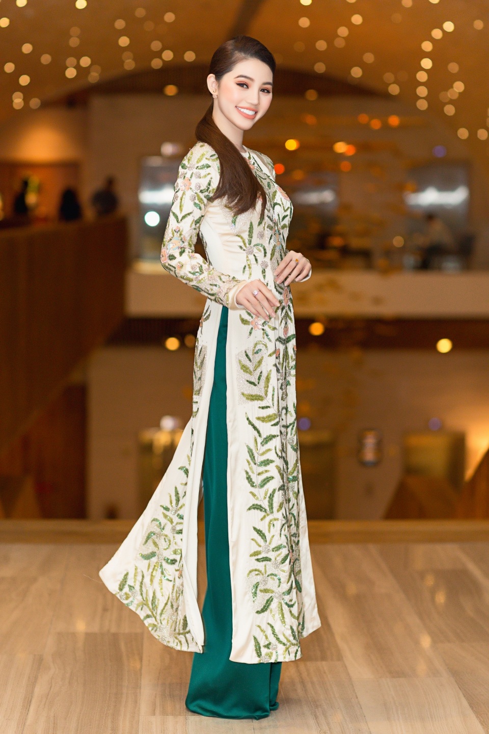 Thoát khỏi vẻ gợi cảm, phong cách thời trang cá tính thường thấy, lần này cô chọn một chiếc áo dài. Bộ trang phục gây ấn tượng với họa tiết thêu tinh xảo, kết hợp cùng kiểu tóc cột đơn giản và tông trang điểm nhấn vào đôi mắt đầy cuốn hút.