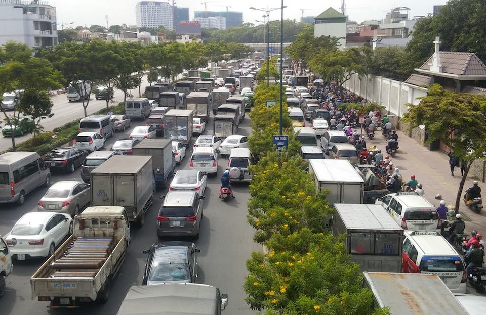Đường Phạm Văn Đồng dẫn vào Tân Sơn Nhất kẹt cứng nhiều giờ - 4 Người dân cho xe máy chạy lên vỉa hè để thoát cảnh kẹt xe