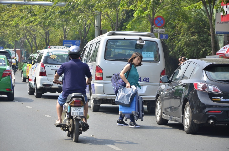 Hành khách "bỏ" taxi, chạy bộ vào Tân Sơn Nhất - 9
Lỉnh khỉnh đồ đạc đi bộ vào sân bay.
