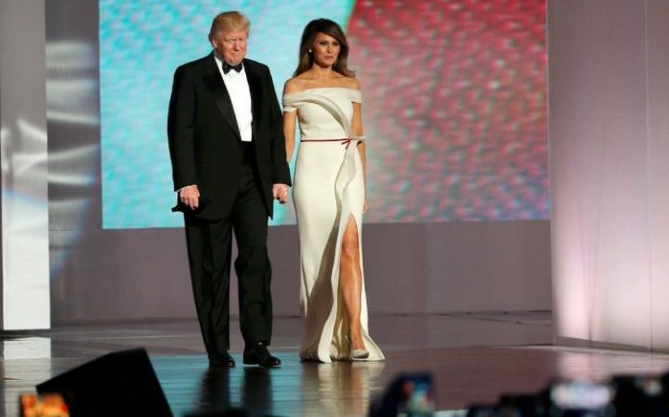 Vợ chồng tân Tổng thống Trump tình tứ trong tiệc khiêu vũ ăn mừng - 1
Tân Tổng thống Donald Trump trong bộ vest đen truyền thống thắt nơ sánh bước cùng Đệ nhất phu nhân Melania trong váy dạ hội trắng tinh tế khi bước ra khán phòng khiêu vũ. (Ảnh: Reuters)