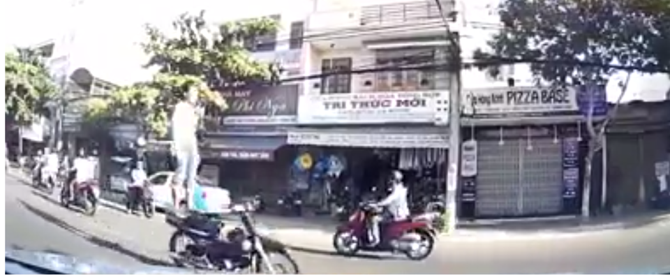 Truy tìm nam thanh niên đứng trên yên xe máy, phóng như bay - 1 Nam thanh niên đứng trên xe máy phóng như bay (ảnh cắt từ clip)