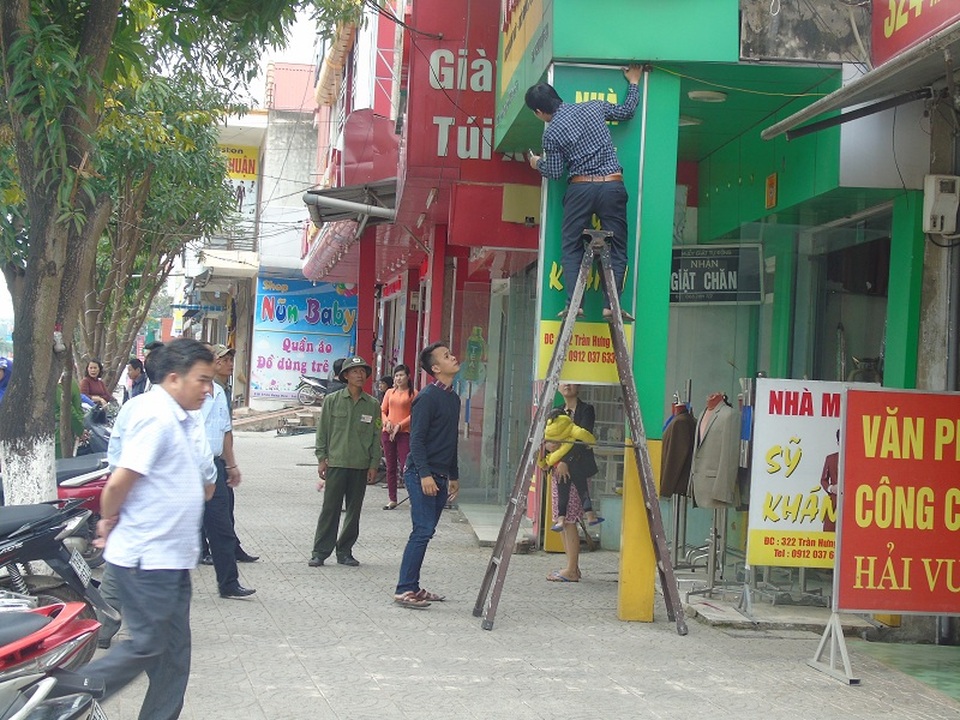 Quảng Bình ra quân giành lại vỉa hè cho người đi bộ - 1 Biển quảng cáo vi phạm lấn chiếm vỉa hè bị tháo dỡ