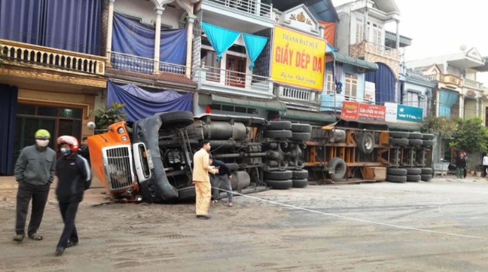 Chiếc xe đầu kéo container trọng tải lớn đổ nghiêng, chặn cửa 4 nhà dân suốt một ngày đêm. Lực lượng cứu hộ phải huy động 4 máy xúc và một xe cứu hộ cùng nhiều nhân lực mới đưa được chiếc xe khủng ra khỏi hiện trường vào ngày 11/12/2016 tại Hòa Bình (ảnh: Đàm Quang)