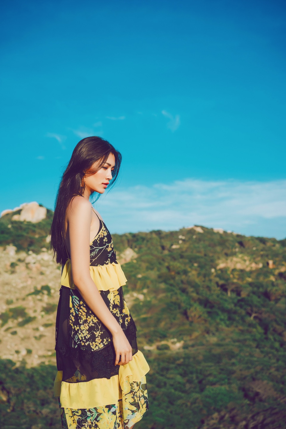 Lệ Hằng như hoà vào không gian thiên nhiên biển trời với sắc vàng của hoa, xanh của lá hay tông trắng, đen kinh điển. Lệ Hằng không mang thêm nhiều trang sức hay phụ kiện vừa tránh cảm giác rối mắt.