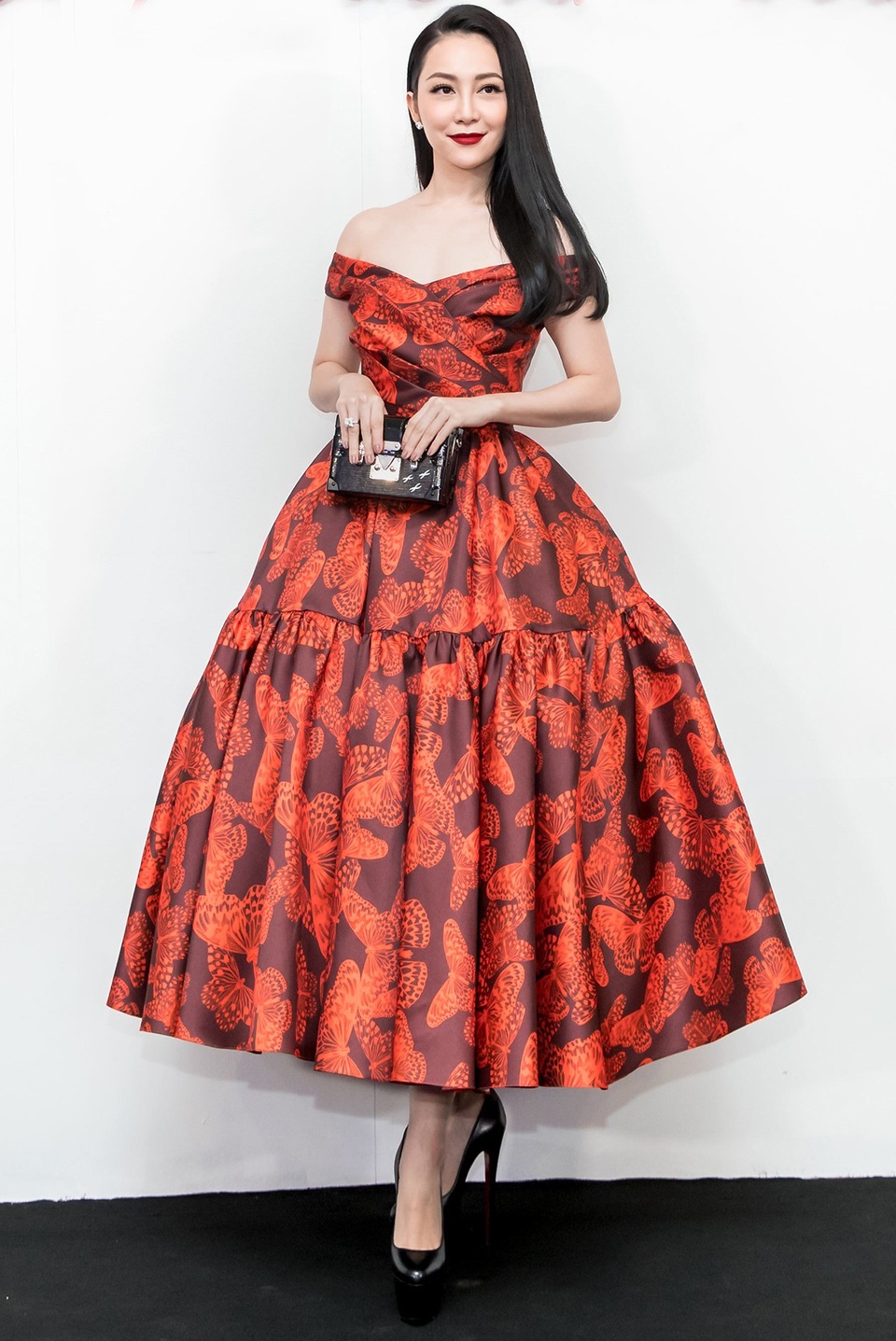 Nghệ sĩ múa Linh Nga diện đầm xòe dịu dàng với họa tiết cánh bướm. Phần váy được tạo điểm nhấn bởi chi tiết gấp nếp, xếp li ở ngực và chân váy. Linh Nga chọn kiểu tóc xõa nhẹ nhàng.