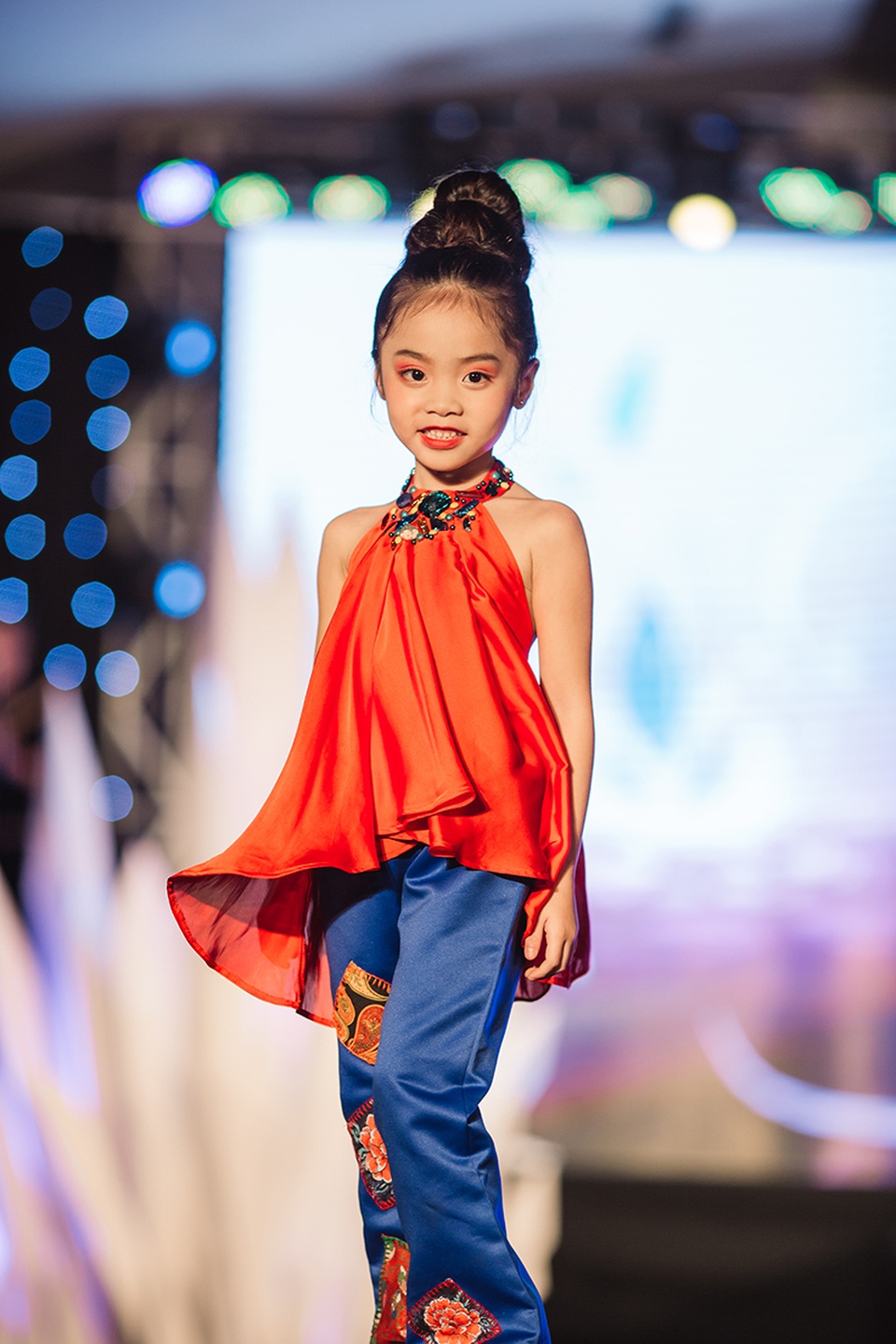100 mẫu nhí tự tin sải bước trên sàn catwalk - 2 Nhiều bé lần đầu tiên được mặc quần áo do các nhà thiết kế nổi tiếng thực hiện, bước đi trên sàn catwalk.