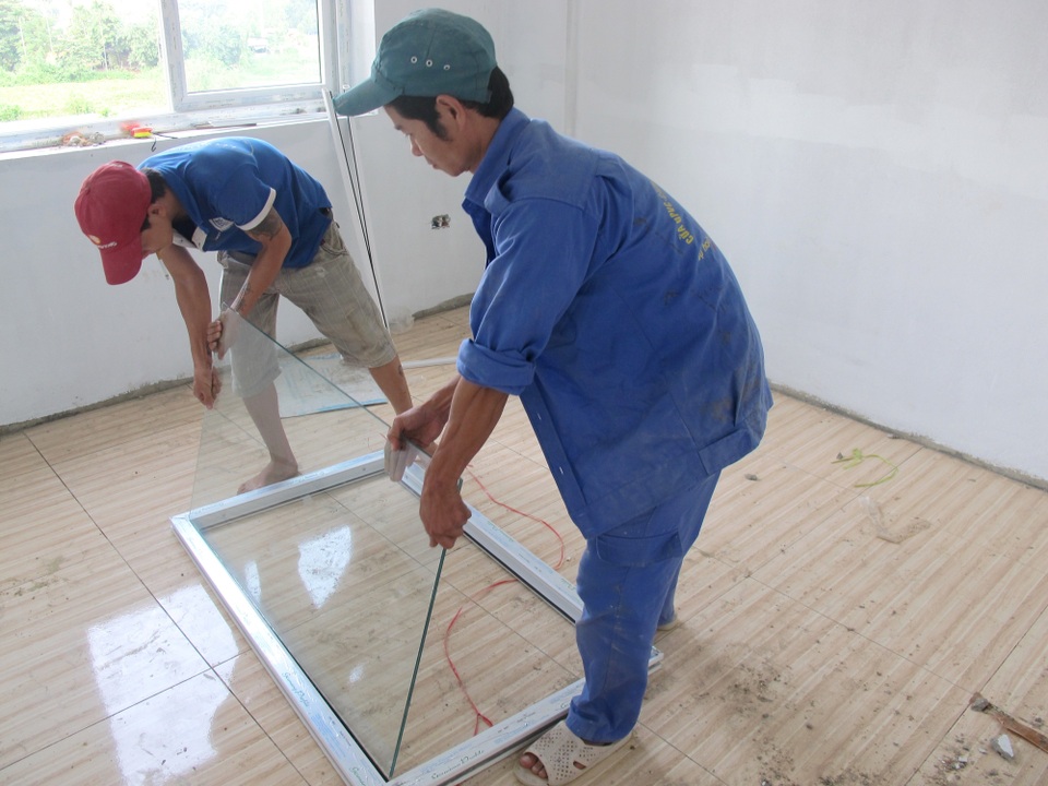 Lý giải nguyên nhân nhà ở xã hội Aranya Huế chậm tiến độ - 5 Các công nhân đang lắp kính cửa được thay từ 6,38 ly lên 8,38 ly