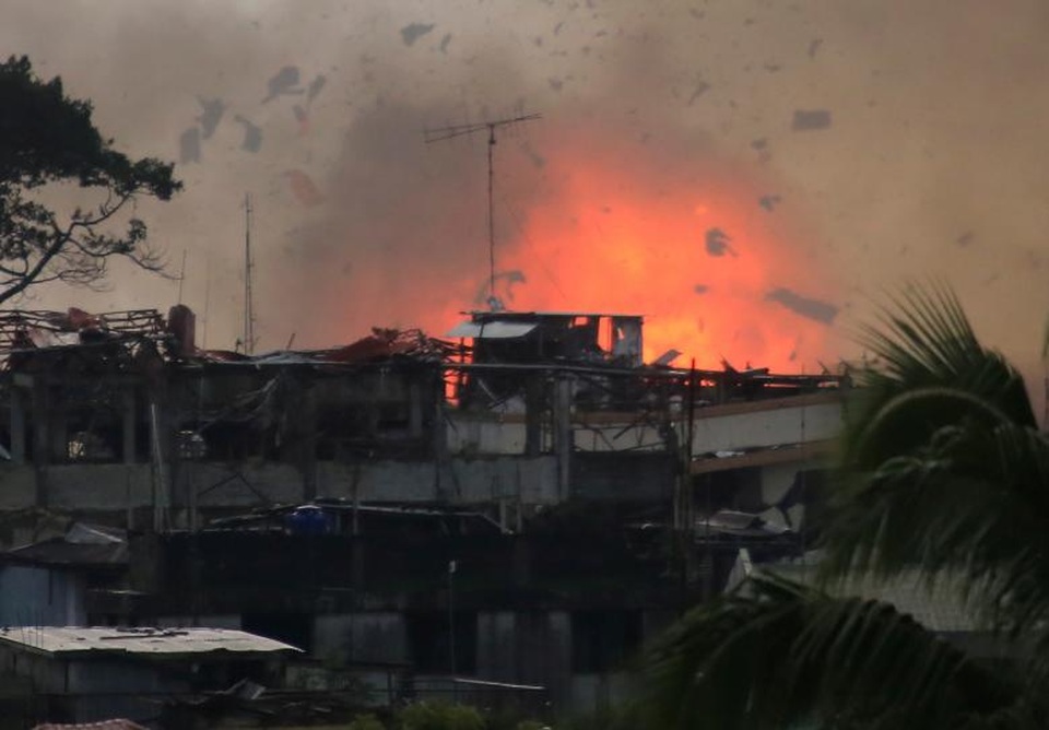 40 phần tử khủng bố nước ngoài tràn vào Philippines - 4 Tổng số người thiệt mạng trong các cuộc giao tranh khốc liệt giữa quân đội chính phủ và các phiến quân tại Marawi suốt 1 tháng qua lên tới 375 người, trong đó có 69 binh sĩ và 26 dân thường. Trong ảnh: Các mảnh vỡ và lửa bốc lên khi máy bay chiến đấu của quân đội Philippines thả bom xuống một khu vực nghi có phiến quân chiếm đóng ở Marawi.