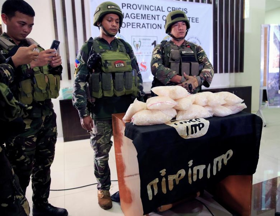 40 phần tử khủng bố nước ngoài tràn vào Philippines - 7 Quân đội Philippines cho biết hiện còn khoảng 100 phiến quân đang cố thủ tại Marawi. Trong ảnh: Các binh sĩ Philippines công bố tang vật gồm 11 kg ma túy đá, ước tính từ 2,2-5 triệu USD, và cờ của IS thu được từ các tay súng của nhóm phiến quân Maute.