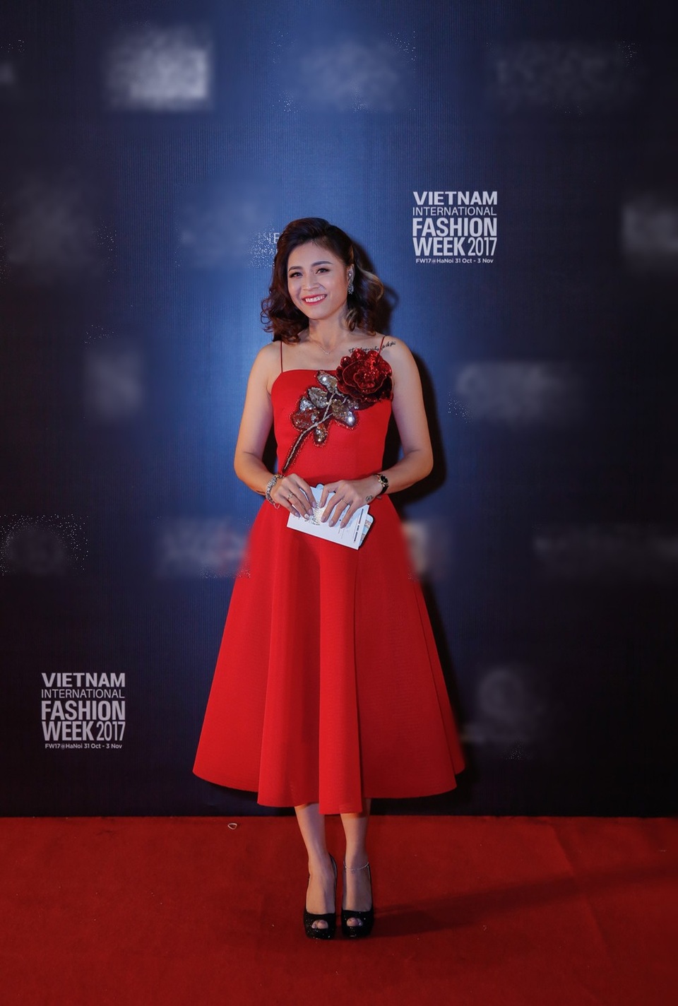 Cô chọn chiếc đầm đỏ hai dây với họa tiết hoa đắp làm điểm nhấn ở phần ngực. Người đẹp làm tóc theo phong cách quý cô cô điển tôn nét đẹp nhẹ nhàng.