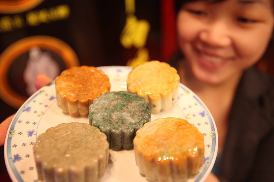 Ngon mắt những chiếc bánh trung thu từ... vàng ròng, ngọc bích - 4 Một nhân viên giới thiệu các loại ngọc bích được đúc hình bánh trung thu tại một triển lãm đồ trang sức ở Bắc Kinh. (Nguồn: IC)