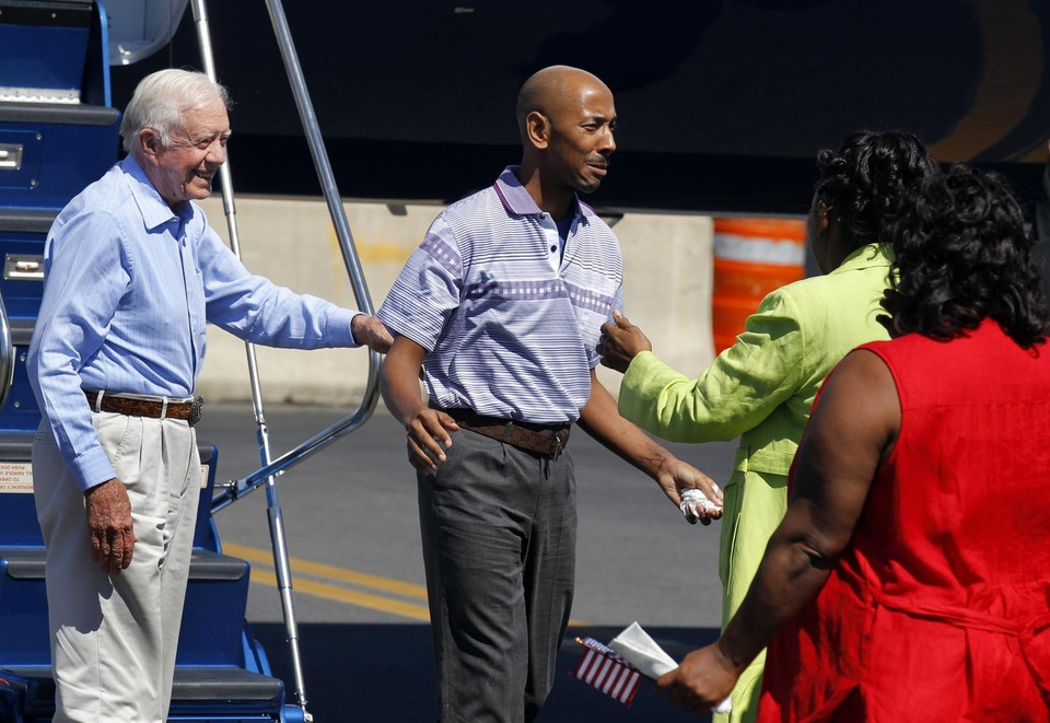 Người Mỹ từng bị Triều Tiên bắt giam chết bí ẩn - 1 Aijalon Mahli Gomes Gomes đoàn tụ với người thân tại Mỹ sau khi trở về từ Triều Tiên năm 2010. Đứng cạnh Gomes là cựu Tổng thống Jimmy Carter (trái) (Ảnh: Reuters)