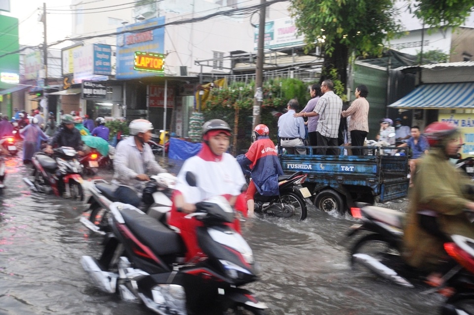 Đường phố Sài Gòn lại ngập nặng sau mưa lớn - 6 Người dân phải thuê xe ba gác để chở qua điểm ngập