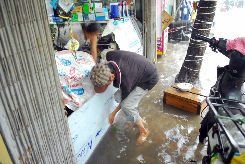Đường phố Sài Gòn lại ngập nặng sau mưa lớn - 8 Che chắn để tránh nước tràn vào nhà