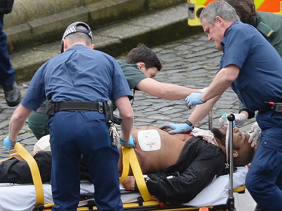 Từ người hàng xóm thân thiện đến kẻ khủng bố rúng động London - 1 Nghi phạm Khalid Masood được đưa lên xe cáng sau khi trúng đạn của cảnh sát trong vụ tấn công khủng bố ở London (Ảnh: PA)
