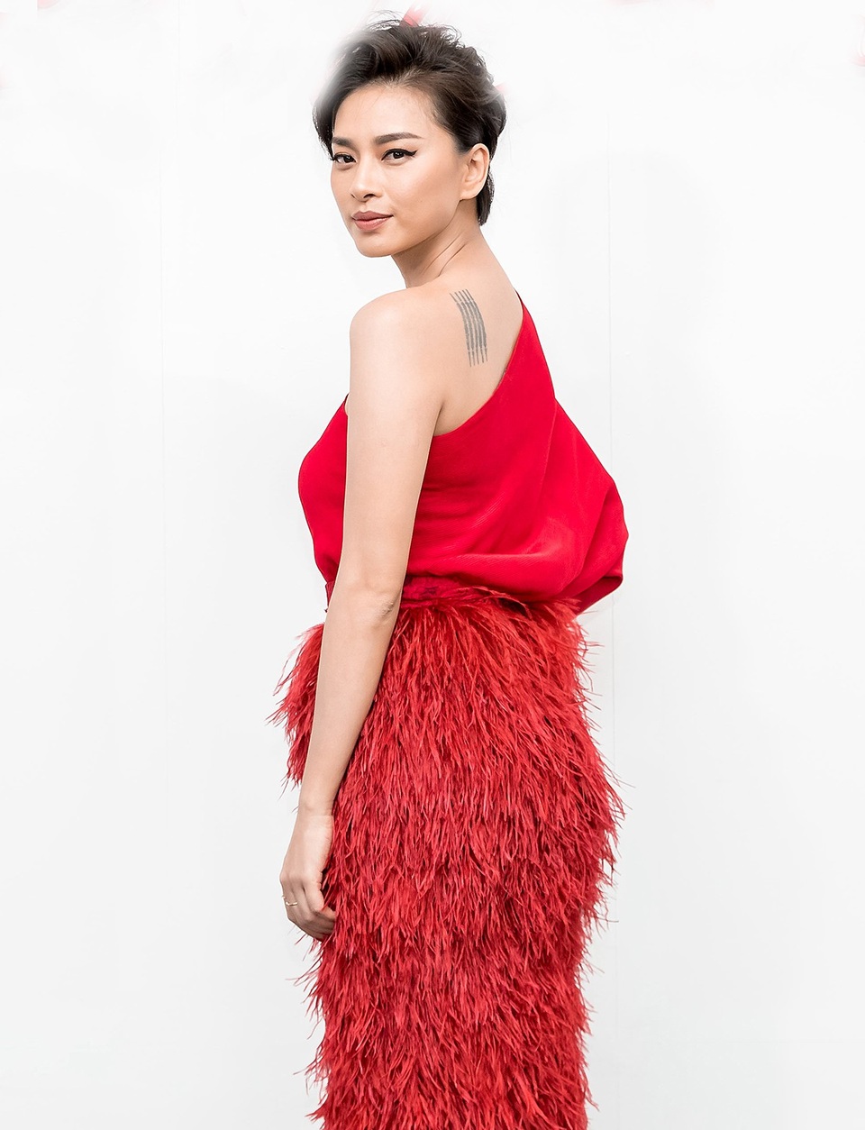 Ngô Thanh Vân kết hợp áo chéo vai cùng chân váy đính lông kỳ công. Nữ đạo diễn làm đẹp với mái tóc búi cổ điển.