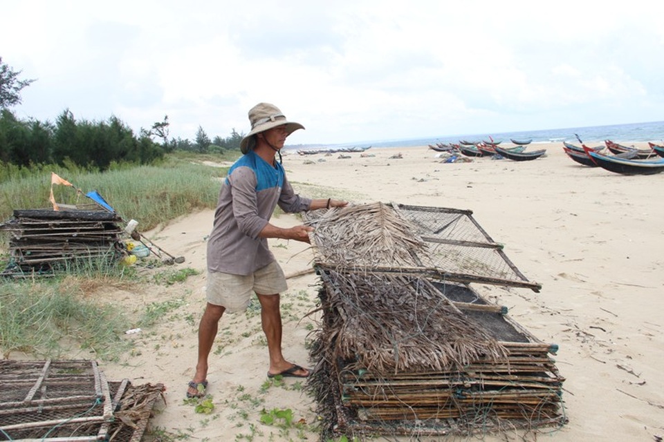 Ngư dân không thể ra khơi vì nước biển bẩn bất thường - 5 Ông Vịnh xếp lại số bẫy mực còn để trên bãi biển