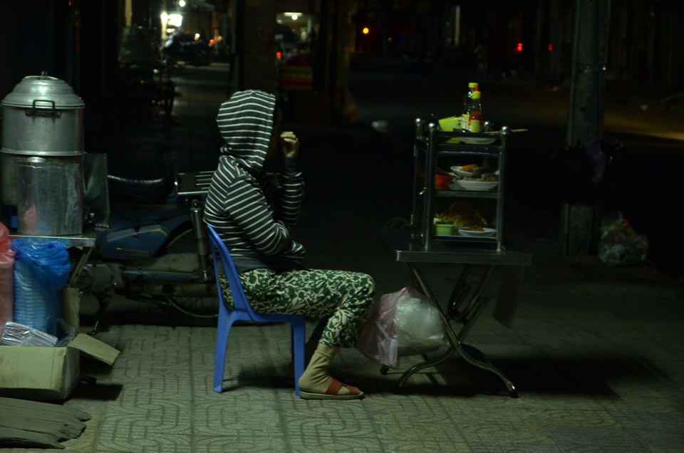 Người Sài Gòn đốt lửa sưởi ấm trong cái lạnh 20 độ C - 6 Một người bán hàng ăn sáng ngồi chờ khách trong thời tiết giá lạnh