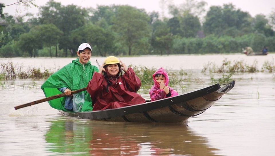 Ba chị em tại huyện Hải Lăng nở nụ cười khi đi giữa vùng ngập lụt
