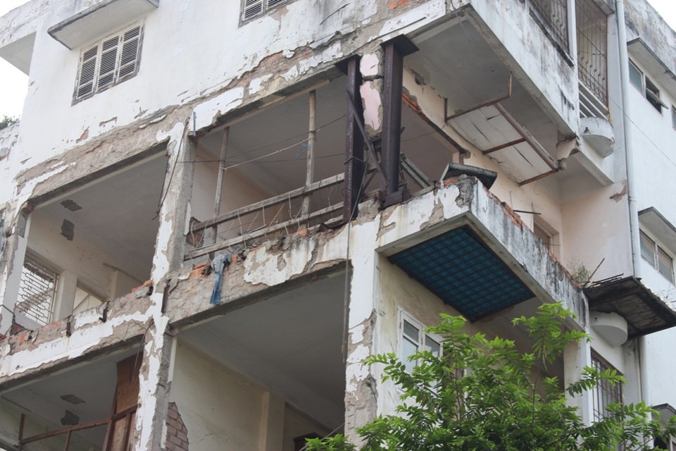 Thấp thỏm trong những ngôi nhà "chờ sập" giữa Thủ đô - 6
Điều đáng nói, trong khi 19 hộ đã di dời đến khu tái định cư Đại Kim, vẫn có 4 hộ gia đình bám trụ, sinh sống tại phần còn lại của căn nhà. Theo lời một số người lớn tuổi sống gần căn nhà này, sau khi chuyển về khu tái định cư, nhiều hộ dân gặp khó khăn trong sinh hoạt và làm việc nên đã quyết định quay trở về và cam kết chịu hậu quả nếu sự cố xảy ra, mặc cho những nguy hiểm đang rình rập ngay bên cạnh.