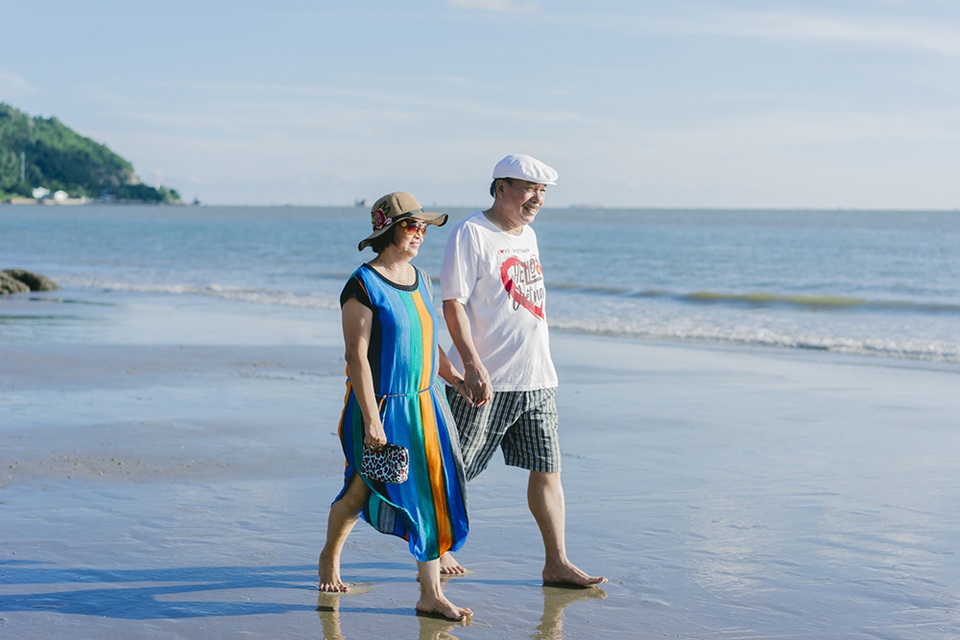 Bước sang tuổi thất thập, nhạc sĩ Trần Tiến vẫn trẻ trung và phong độ với quần jean lửng, áo thun mỗi khi đi dạo biển cùng vợ.