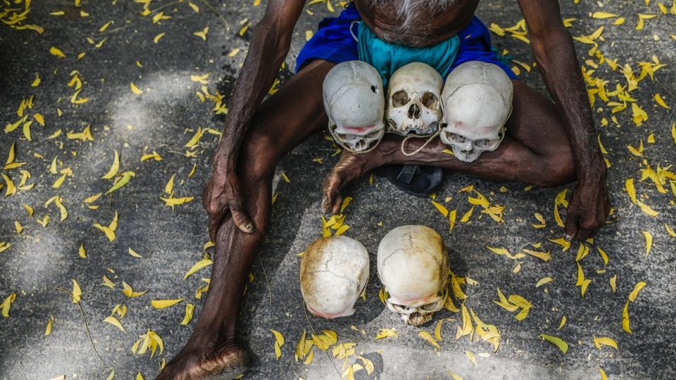 Vì sao gần 60.000 nông dân Ấn Độ tự tử trong 30 năm qua? - 1 Một nông dân từ bang Tamil Nadu ngồi ôm những chiếc đầu lâu từ những người nông dân tự tử trong khu vực. (Ảnh: Bloomberg)