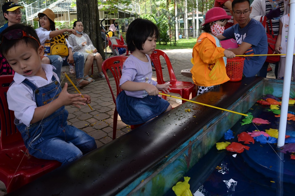 Khu vui chơi ở Sài Gòn đông nghịt người du xuân, vãn cảnh... - 9 Các em nhỏ ngồi câu cá nhựa khi được bố mẹ dẫn đi chơi Xuân.