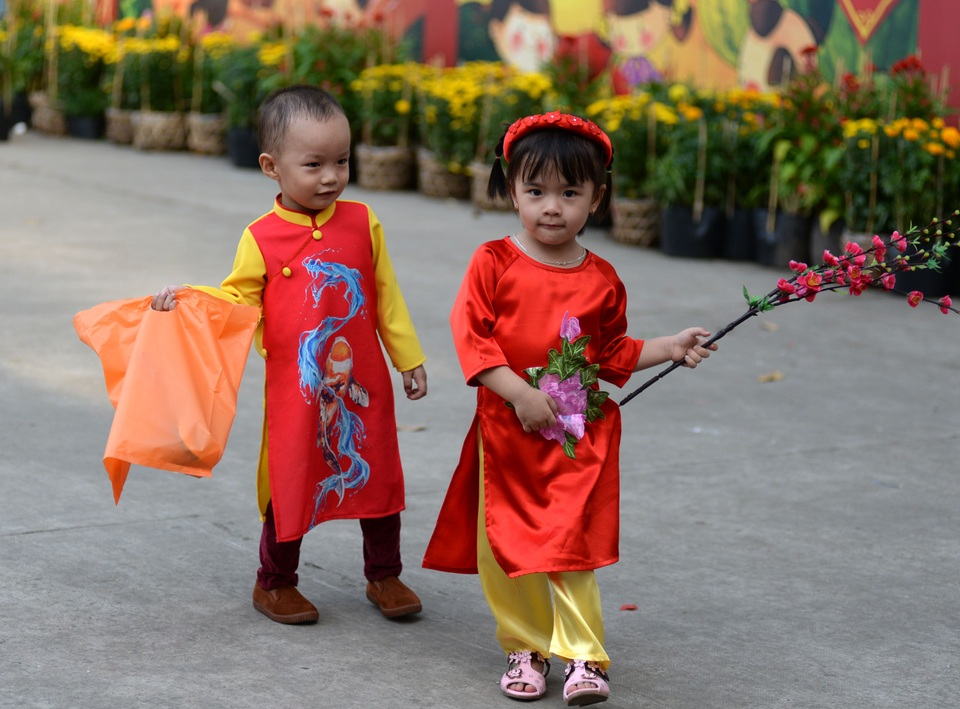 Những cô bé, cậu bé tung tăng với chiếc áo dài trong ngày cuối năm.