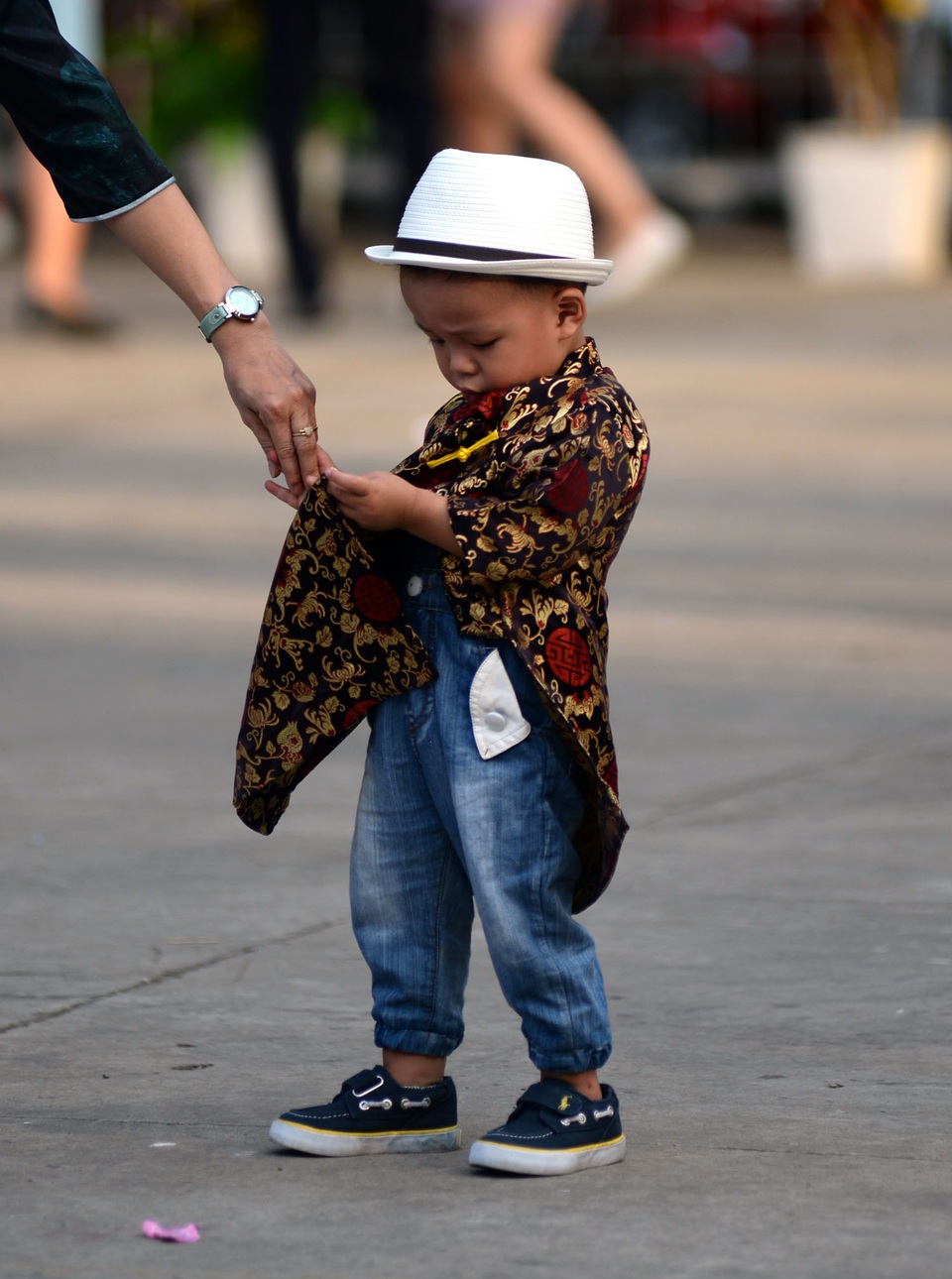 Cậu bé lạ lẫm vì lần đầu tiên mặc áo dài.