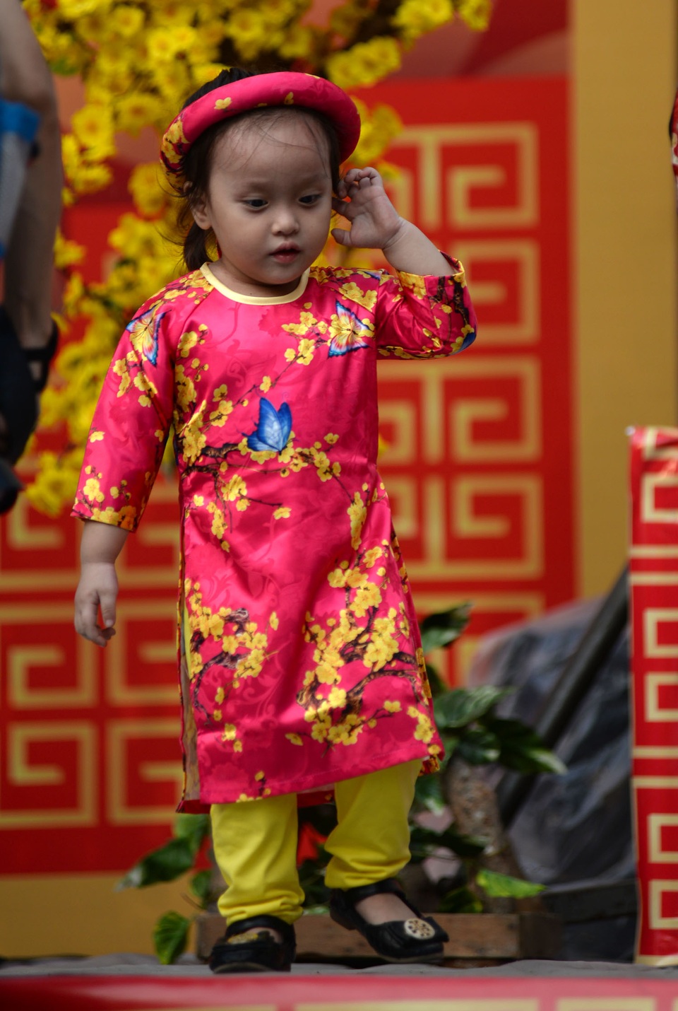 Chiếc áo dài với họa tiết cành đào, những con bướm của em bé nhỏ tuổi.