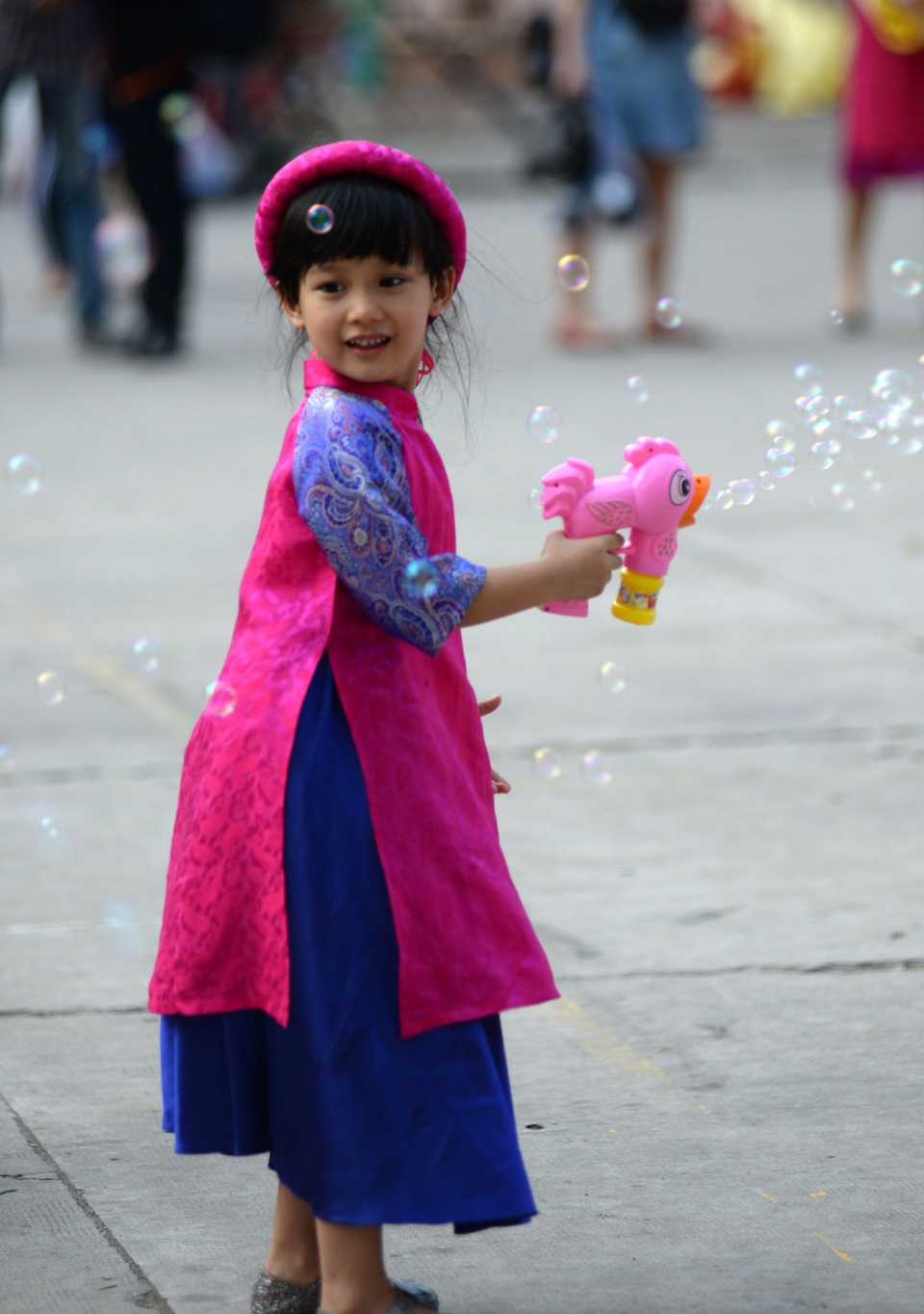 Trong trang phục áo dài, cô bé xinh xắn, nhí nhảnh.