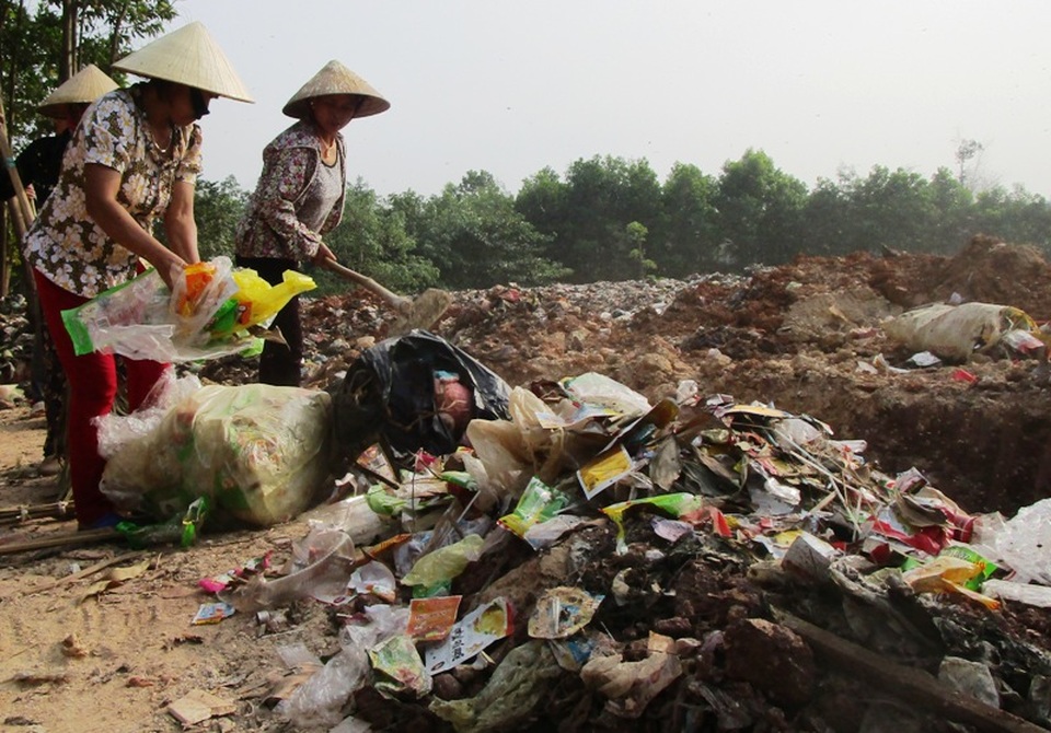 Người dân dựng lán giữa đường phản đối bãi rác gây ô nhiễm - 1 Người dân gom rác thải đổ ra đường