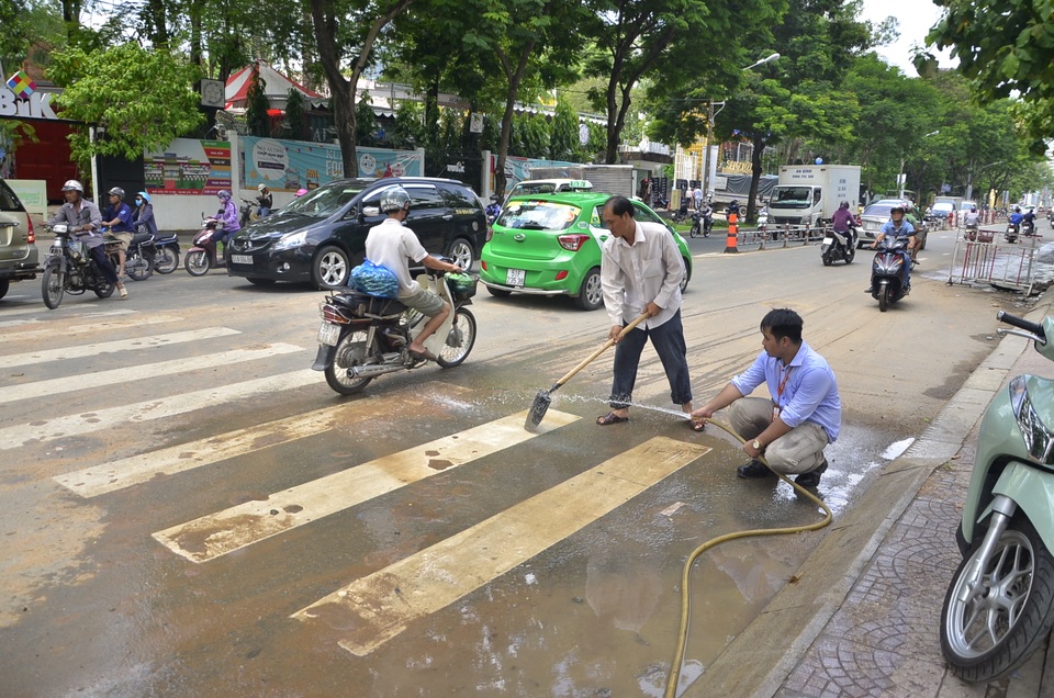 Ông Đoàn Ngọc Hải gọi điện yêu cầu phạt ngay đơn vị "rải" bùn ra đường - 4 Đại diện đơn vị thi công tiến hành xả nước để chùi rửa mặt đường sau khi bị lập biên bản