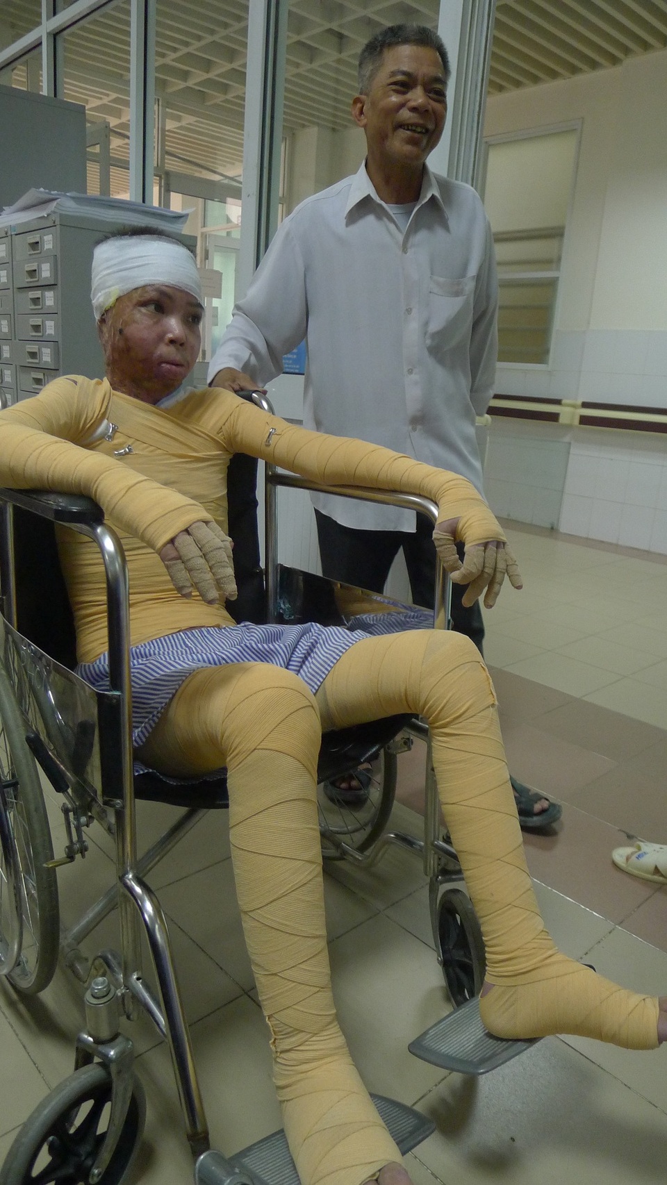Chàng trai bị bỏng do nổ bình ắc quy xe đạp đã được xuất viện - 6 Hai bố con vui mừng lên chào các bác sĩ ở khoa Hồi sức cấp cứu trước khi về nhà.