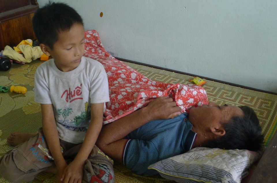 Cậu bé Quân 8 tuổi sau giờ lên lớp, em chỉ quanh quẩn với bố.