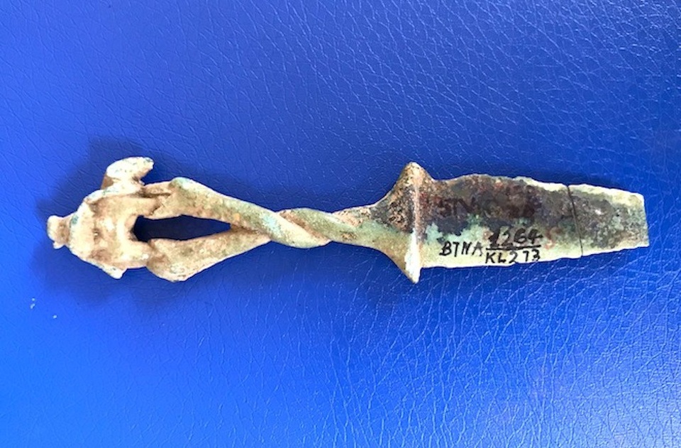 Hiện vật này có 2 phần gồm lưỡi và chuôi. Lưỡi dao mỏng, dài 5,5cm, hình giống hình tam giác. Mũi dao nhọn, hai đầu chắn tay có hình râu bướm. Phần chuôi dao dài 6,8cm. Đặc biệt phần chuôi có hình hai con rắn thân tròn xoắn lấy nhau. Miệng rắn mở to, có đôi mắt lồi và 2 con rắn đang há miệng đỡ lấy cặp chân sau và cặp chân trước của một con voi.