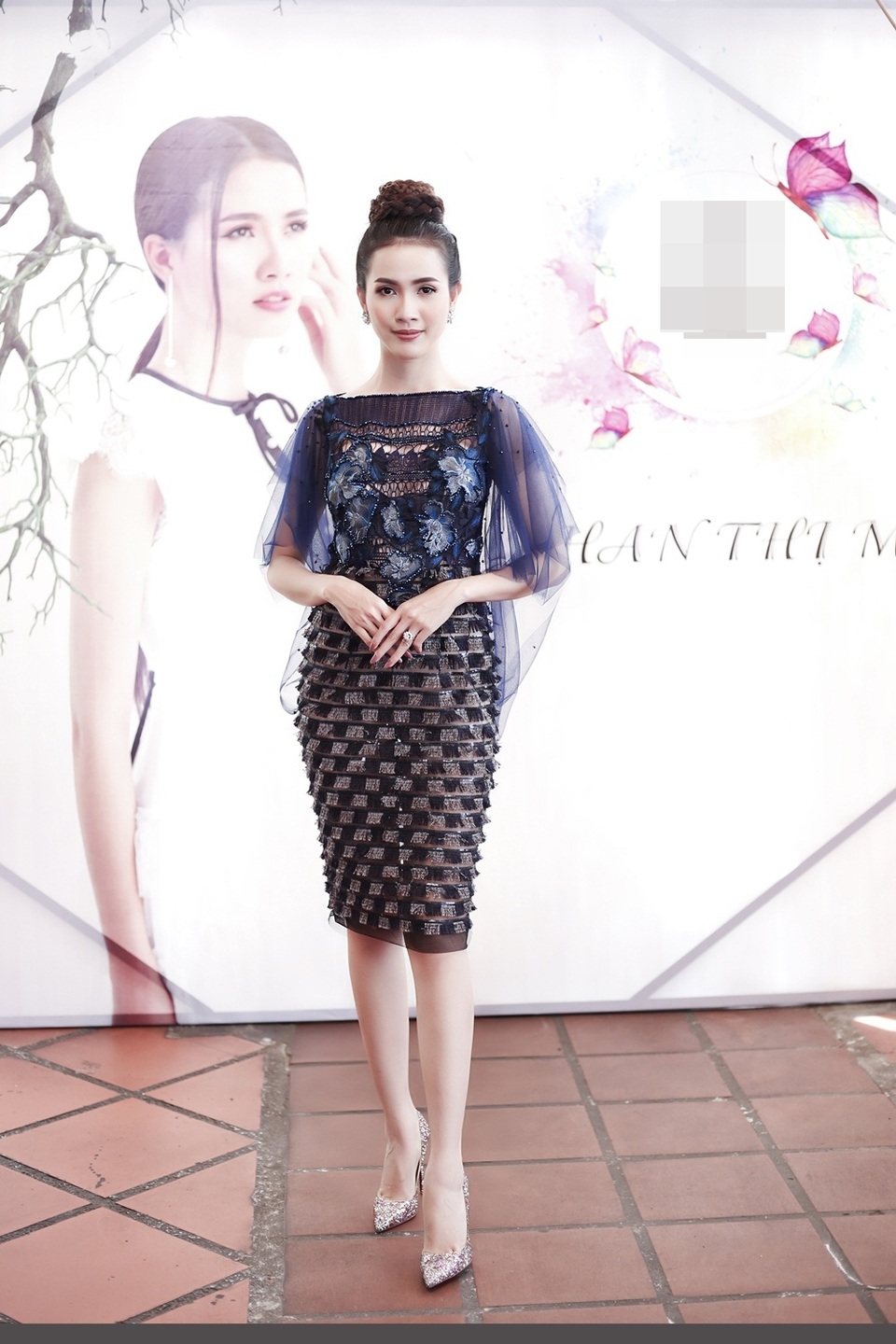 Bên cạnh đó, mái tóc được búi cao kết hợp cùng đôi bông tai đính đá cùng với đôi giày cao gót lấp lánh mang lại vẻ ngoài thu hút.