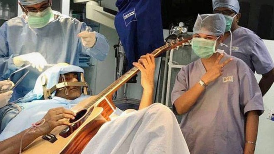 Hy hữu bệnh nhân vừa mổ não vừa chơi ghi ta - 1 
Anh Abhishek Prasad chơi ghi ta ngay trên bàn mổ. (Ảnh: PTI)