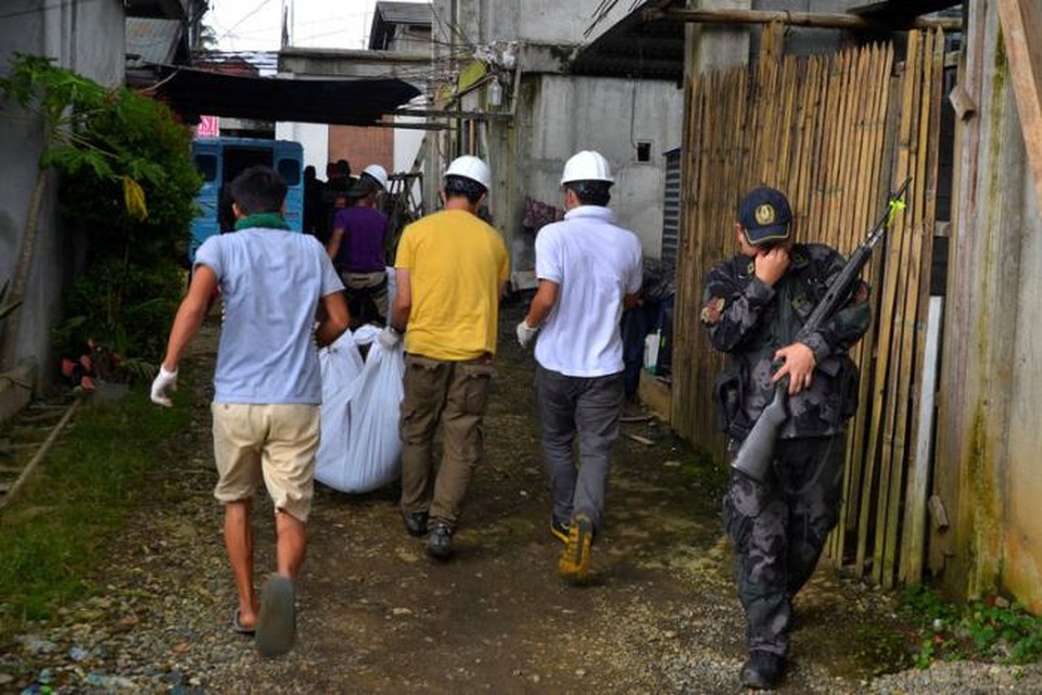 “Biệt đội cảm tử” cứu dân thường mắc kẹt tại vùng chiến sự ở Philippines - 1 Nhóm các tình nguyện viên đội mũ bảo hiểm trắng đưa thi thể nạn nhân thiệt mạng trong cuộc giao tranh tại thành phố Marawi tới khu vực an táng (Ảnh: Reuters)